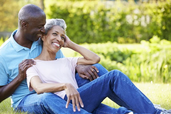 Pareja sentada en jardín — Foto de Stock