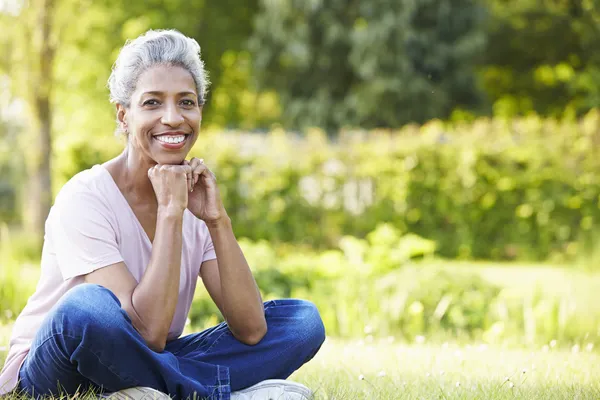 Frau sitzt im Garten — Stockfoto