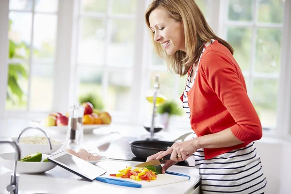 Femme dans la cuisine suivant la recette — Photo