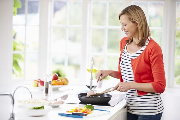 Vrouw stond op de kookplaat — Stockfoto