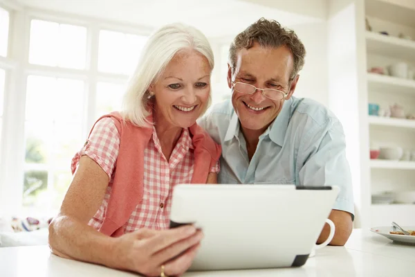 Mellersta åldern par titta på digital tablet — Stockfoto