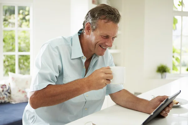 Człowiek za pomocą cyfrowego tabletu na śniadanie — Zdjęcie stockowe