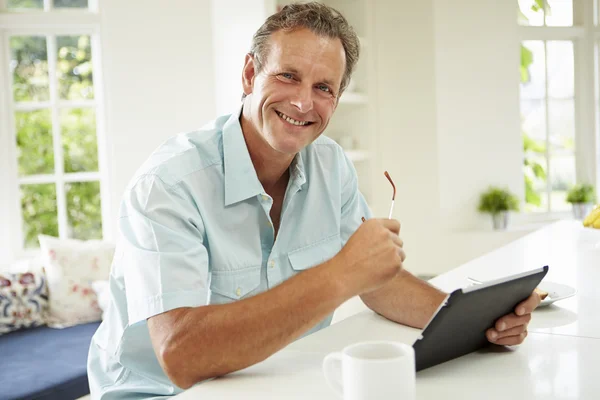 Homem usando tablet digital durante o café da manhã — Fotografia de Stock