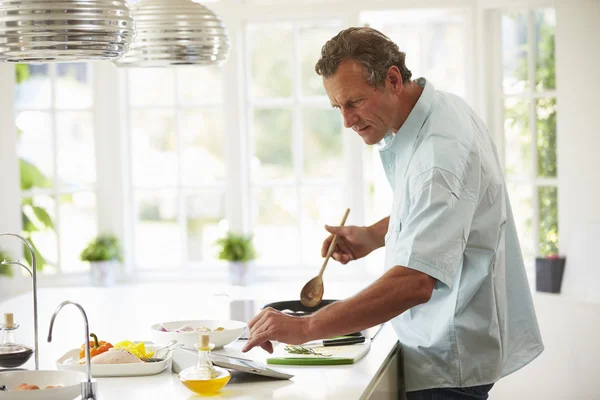 Uomo seguendo la ricetta su tavoletta digitale — Foto Stock