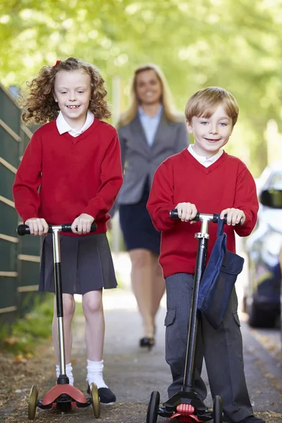 Children Riding Scooters Royalty Free Stock Images