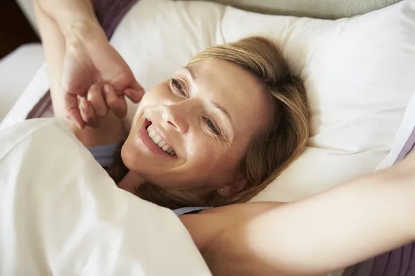 Frau wacht im Bett auf — Stockfoto