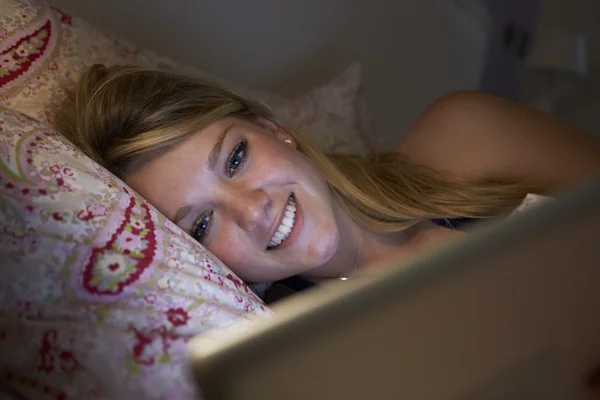 Fille à l'aide d'une tablette numérique au lit — Photo