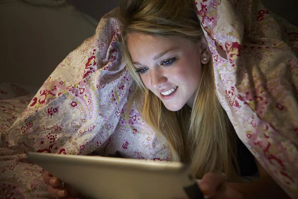Mädchen mit digitalem Tablet im Bett — Stockfoto