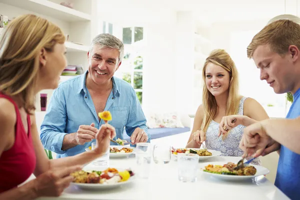 Gezin met tienerkinderen eten van maaltijd — Stockfoto