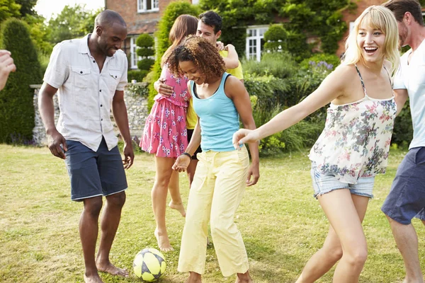 Vrienden voetballen in tuin — Stockfoto