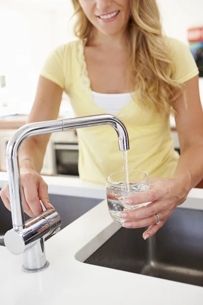 Frau gießt Glas Wasser ein — Stockfoto