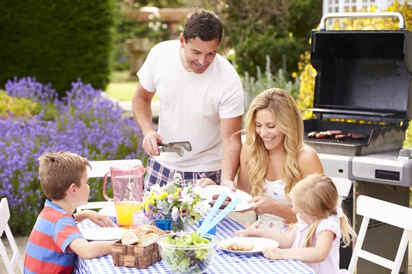 Família desfrutando de churrasco ao ar livre — Fotografia de Stock