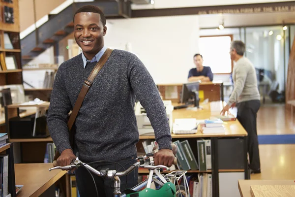 Architekt kommt mit Fahrrad zur Arbeit und schiebt es durch Büro — Stockfoto