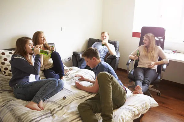 Tieners drinken van alcohol in de slaapkamer — Stockfoto