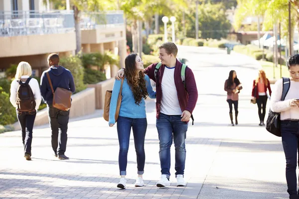 Pareja de estudiantes caminando al aire libre en el campus universitario — Foto de Stock