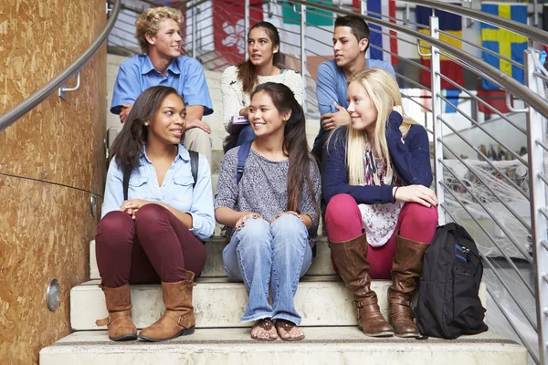 Middelbare scholieren zitten buiten gebouw — Stockfoto