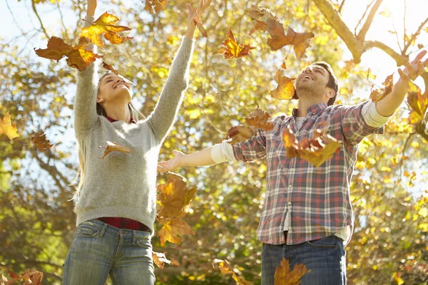 Coppia lancio autunno foglie in aria — Foto Stock