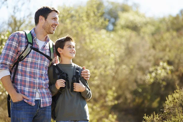 Vader en zoon wandelen in het platteland dragen van rugzakken — Stockfoto