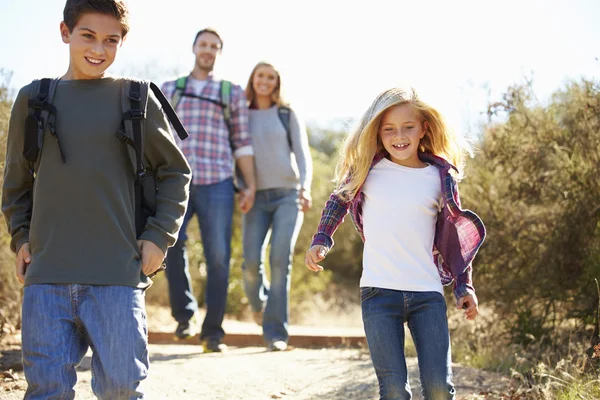 Madre e hijos caminando en el campo usando mochilas —  Fotos de Stock