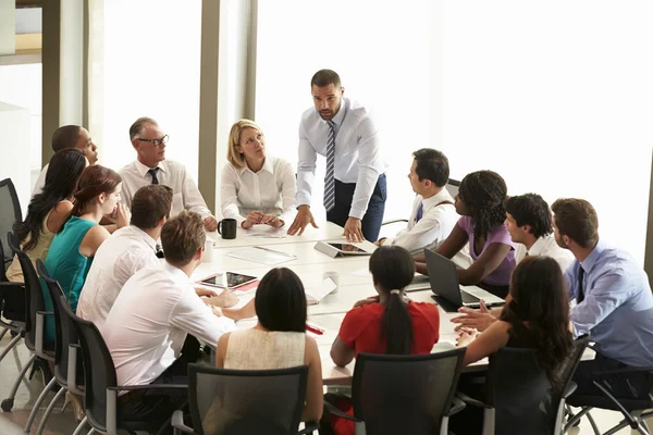 Empresario dirigiéndose a la reunión alrededor de la mesa de la sala de juntas Fotos De Stock Sin Royalties Gratis