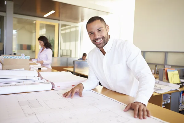 Arquitecto masculino estudiando planes en la oficina — Foto de Stock