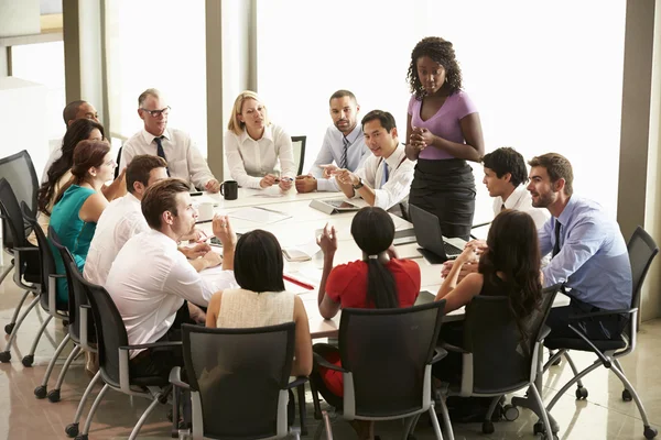 Businesswoman si rivolge incontro intorno al tavolo della sala riunioni — Foto Stock