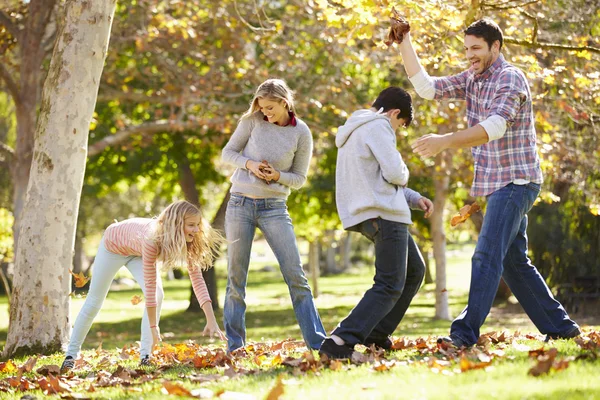 Familia lanzando hojas de otoño en el aire — Foto de Stock