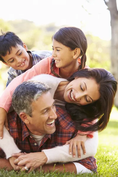 Familjen ligger på gräset på landsbygden — Stockfoto