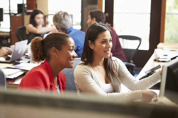 Due colleghi che lavorano alla scrivania con riunione in background — Foto Stock