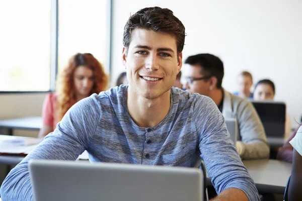 Erkek üniversite öğrenci sınıfta dizüstü bilgisayar kullanmak — Stok fotoğraf