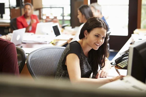 Femme d'affaires travaillant au bureau avec réunion en arrière-plan — Photo