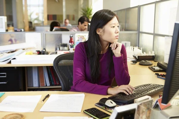 Aziatische vrouw werken bij computer in moderne kantoor — Stockfoto