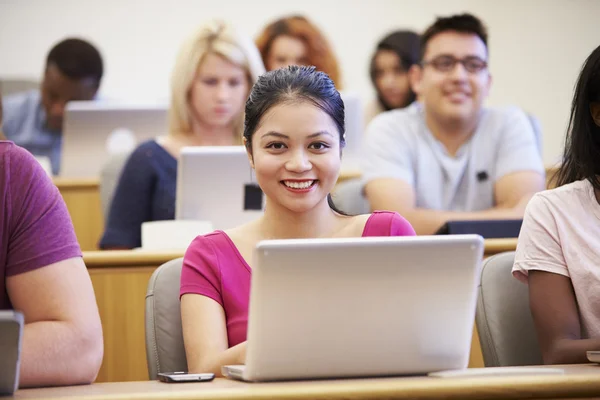 Estudante universitário feminino usando laptop na palestra — Fotografia de Stock