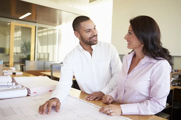 Architetti che studiano i piani in ufficio moderno insieme — Foto Stock