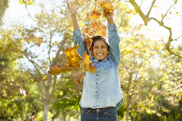 Joven chica lanzando hojas de otoño en el aire — Foto de Stock