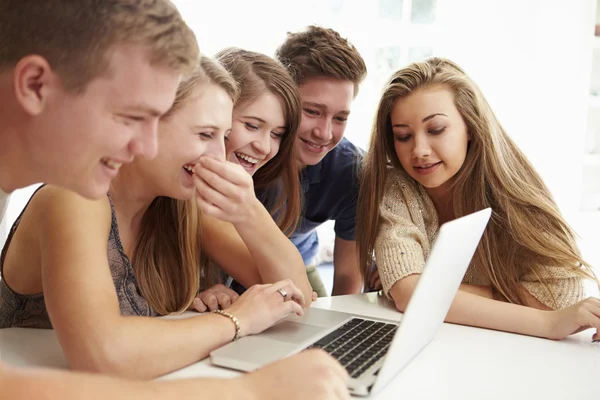 Adolescentes reunidos alrededor del ordenador portátil — Foto de Stock