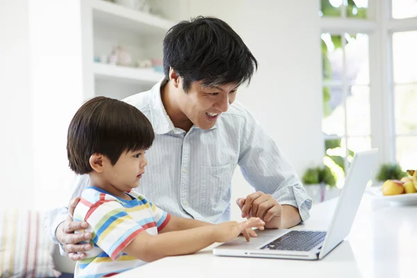 Pai ajudando filho a usar laptop — Fotografia de Stock