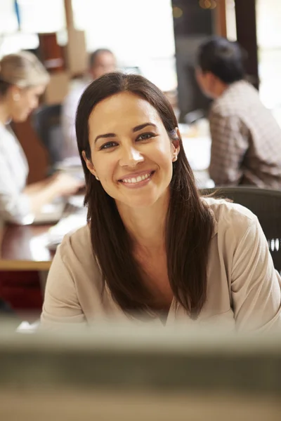 Zakenvrouw werken bij receptie met vergadering in achtergrond — Stockfoto