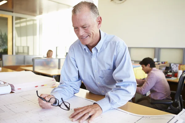 Arquiteto masculino estudando planos no escritório — Fotografia de Stock