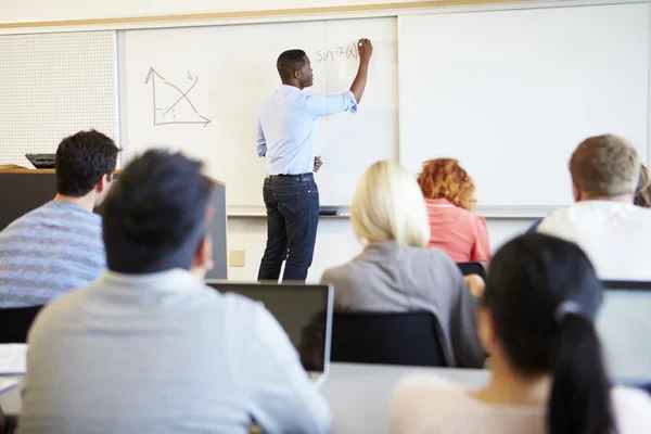 Mannelijke leraar lesgeven universitaire studenten in de klas — Stockfoto