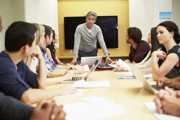 Jefe masculino dirigiéndose a la reunión alrededor de la mesa de la sala de juntas — Foto de Stock