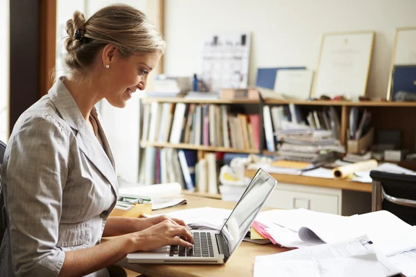 Vrouwelijke architect werken bij desk op laptop — Stockfoto