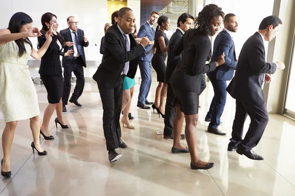 Geschäftsleute und Geschäftsfrauen tanzen in Bürolobby — Stockfoto