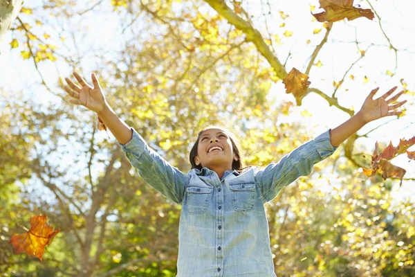 Joven chica lanzando hojas de otoño en el aire —  Fotos de Stock