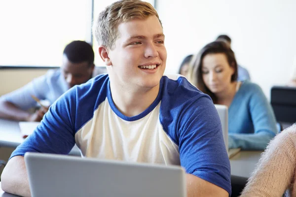 Erkek üniversite öğrenci sınıfta dizüstü bilgisayar kullanmak — Stok fotoğraf