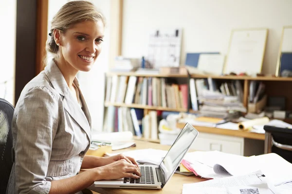 Vrouwelijke architect werken bij desk op laptop — Stockfoto