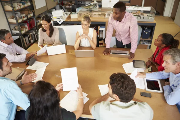 Arquitectos sentados en la reunión de mesa con computadoras portátiles y tabletas — Foto de Stock