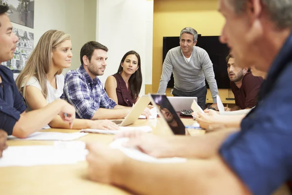 Jefe masculino dirigiéndose a la reunión alrededor de la mesa de la sala de juntas — Foto de Stock