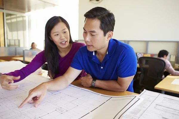 Arquitetos estudando planos no escritório moderno juntos Imagem De Stock