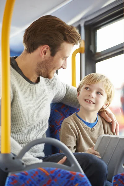Сын с помощью цифровой планшет в автобусе путешествие с отцом — стоковое фото